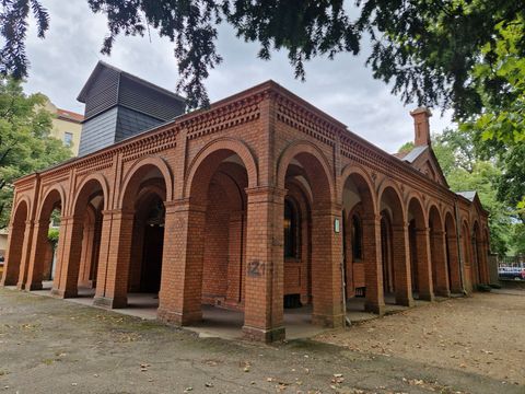 Außenansicht von der Aufbahrungshalle auf dem Sankt Thomas Friedhof, Backsteingebäudekubus mit Säulengang