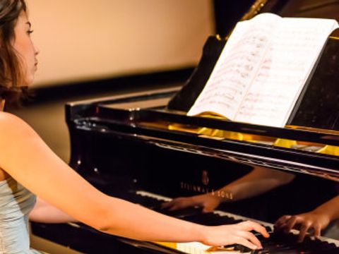 Frau spielt an einem Flügel