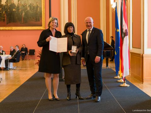 Gisela Greiner (mitte) wird vom Regierenden Bürgermeister Kai Wegner (re.) zur Stadtältesten ernannt. In Anwesenheit der Präsidentin des Abgeordnetenhauses Cornelia Seibeld (li.)
