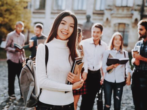 Schülerin lächelnd mit Mappen