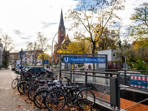 U-Bahn-Eingang mit Fahrradabstellplätzen, Kirche im Hintergrund