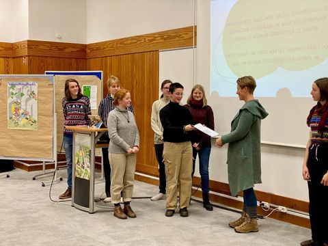 mehrere Personen bei der Übergabe des Forderungspapiers