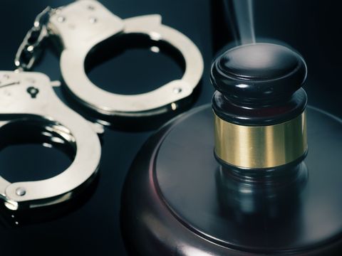 Gerichtssaal-Hammer und Handschellen daneben