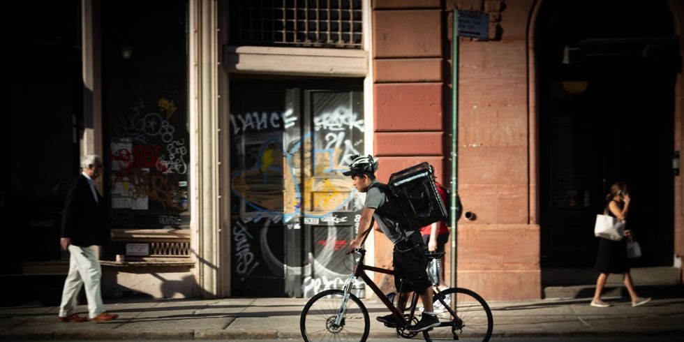 Fahrrad-Kurier eines Zustelldienstes beim Fahren auf der Straße