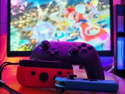 Videospiel-Controller vor Bildschirm mit Mario Kart