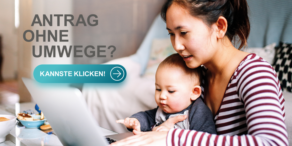 Eine Frau mir ihrem Baby auf dem Arm sitzt vor einem Laptop