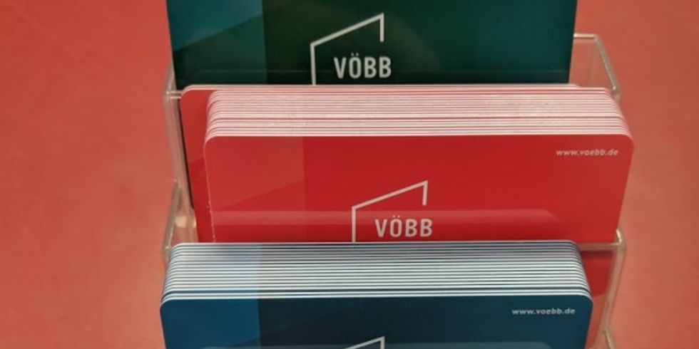 Mehrere Bibliotheksausweise gestaffelt in unterschiedlichen Farben