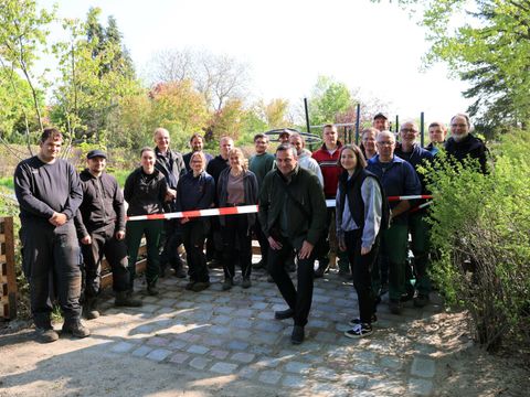 Auszubildende und Mitarbeitende des Fachbereichs Grünflächen zusammen mit Bezirksstadtrat Urban Aykal bei der Eröffnung nach vollständiger Sanierung des Spielplatzes im Orlamünder Weg (Bild: Bezirksamt Steglitz-Zehlendorf)