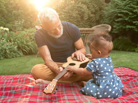 Mann mit Baby und Ukulele