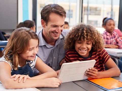 Lehrer mit Schülerin und Schüler und Tablet