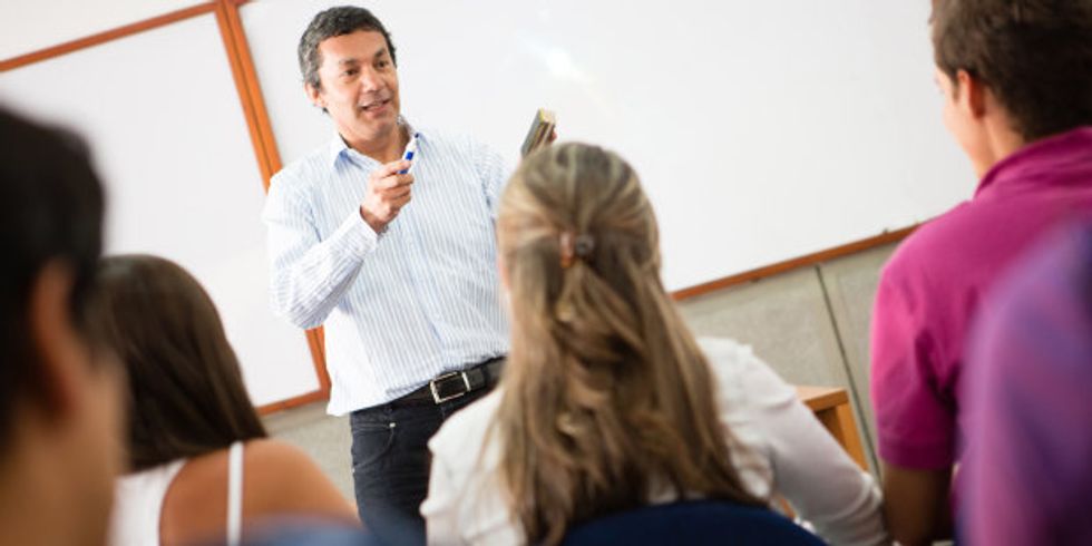 Lehrer steht vor den Schülern und erklärt