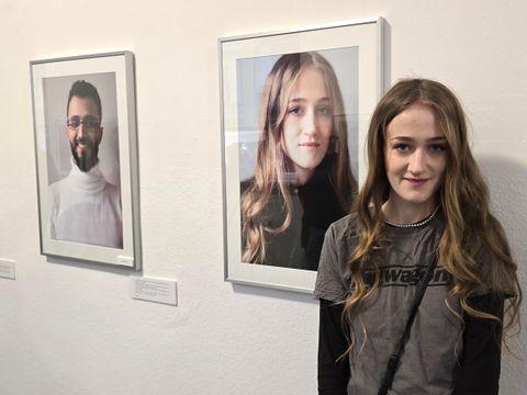 Absolventin Diana vor ihrem Portrait