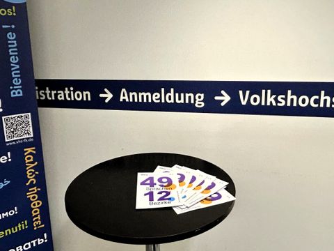 Der Eingangsbereich der VHS Friedrichshain-Kreuzberg mit Flyern zum Fremdsprachenangebot.