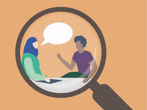 Ein Beratungsgespräch von zwei Personen, betrachtet durch eine Lupe.