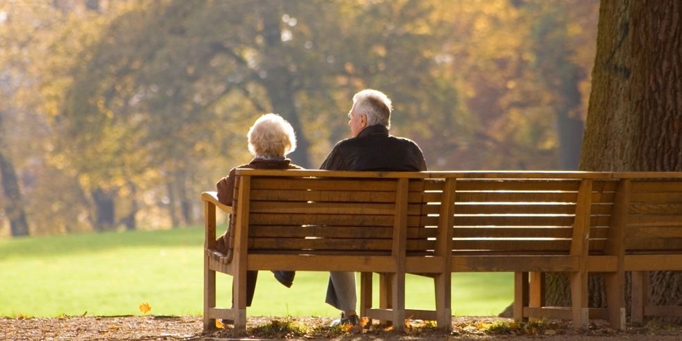 Zwei alten Menschen sitzen im Park auf einer Bank