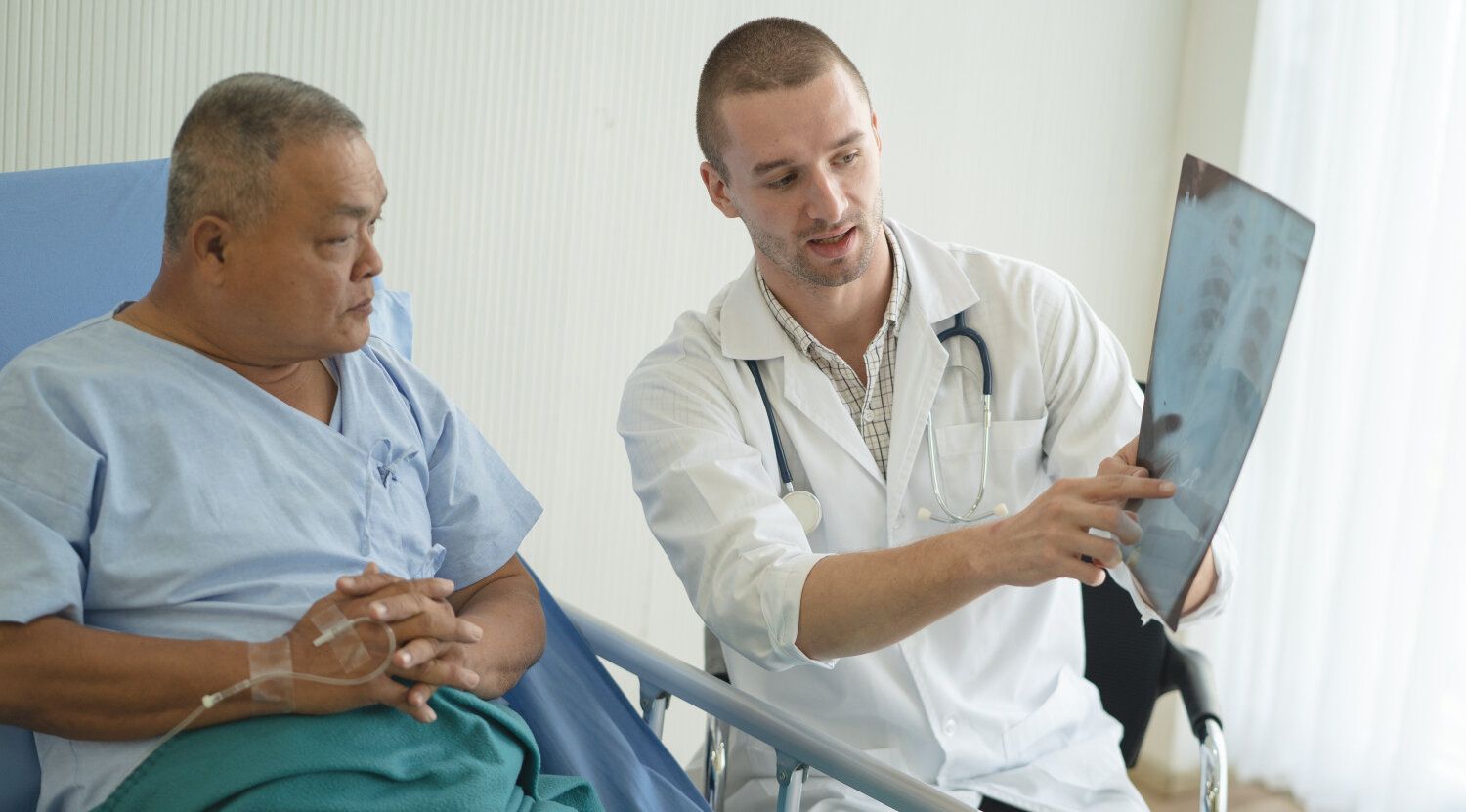 Arzt zeigt einem Patienten Röntgenbild und bespricht die Diagnose 