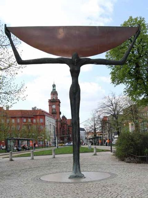 Die Skulptur „Viertelmondträgerin“ mit dem Rathaus im Hintergrund