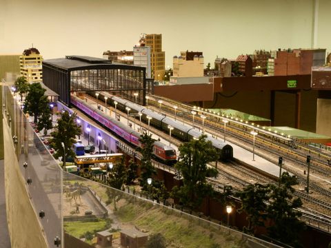 Eine Modelleisenbahn fährt durch eine Bahnhofshalle.