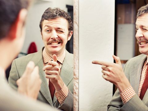 Man looking at reflection in mirror