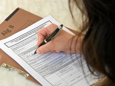 Frau füllt Antrag auf Alg II aus