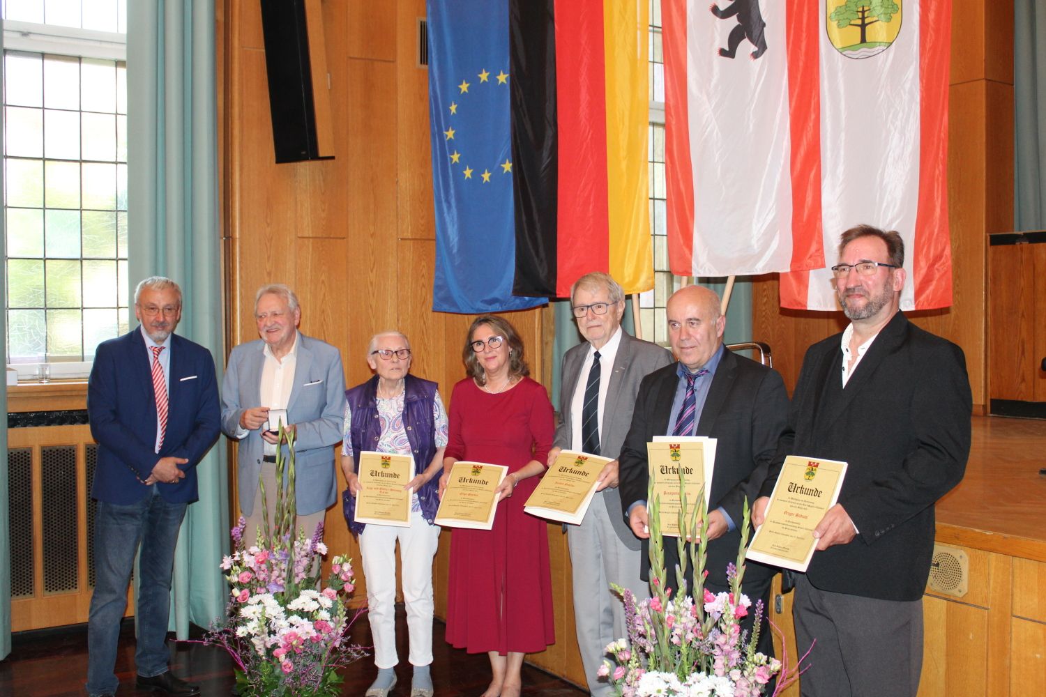 5. Juli 2023: Gruppenbild aller Trägerinnen und Träger der Bezirksmedaille 2023: Mitte Olga Pischel, 2.v.r. Panagiotis Matlis, 2.u.3.v.l. Günter-Henning und Inge Tarun