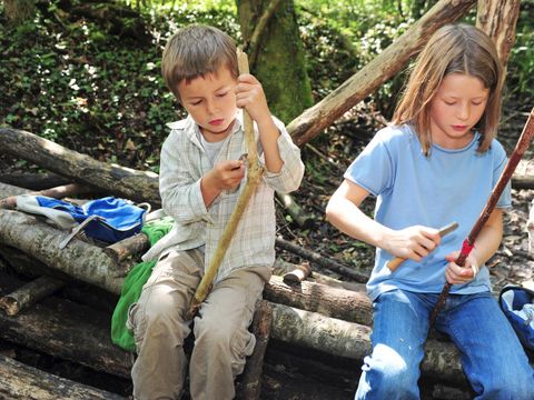 Schnitzende Kinder im Wald