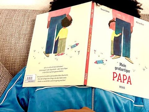 Mann ist mit Kinderbuch vorm Gesicht eingeschlafen