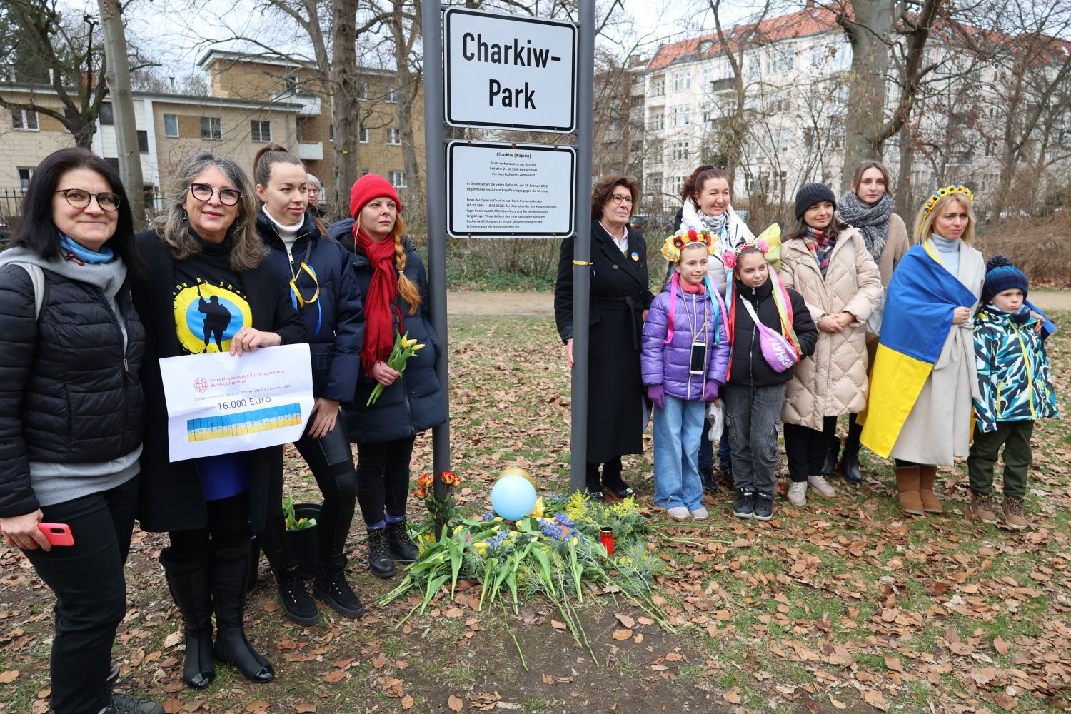 24. Februar 2024: Bezirksbürgermeisterin Schellenberg (rechts neben dem Schild) mit Mitgliedern der ukrainischen Community. Olga Pischel (2.v.l.) zeigt 16.000-Euro-Spende der ev. Pauluskirchengemeinde Lichterfelde.