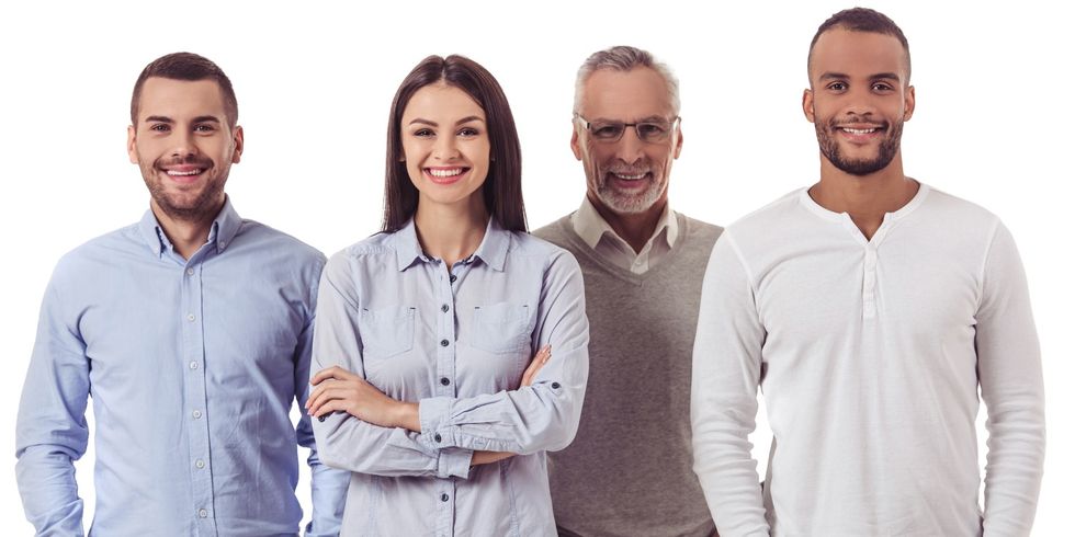 Gruppe aus vier Personen ist der Kamera zugewandt und lächelt