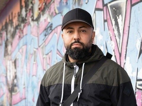 Ein Mann steht vor einer Wand mit Grafiti