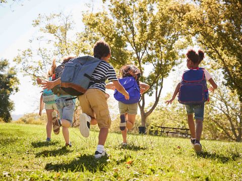 Schulkinder rennen durch einen Park