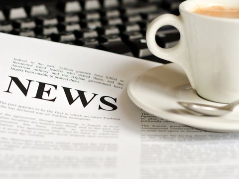Kaffeetasse steht auf einer Tageszeitung