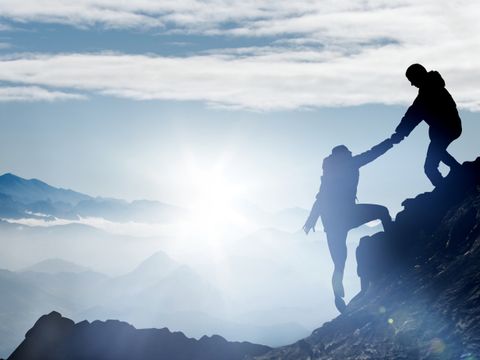 Bergsteiger helfen einander, den Gipfel zu erreichen