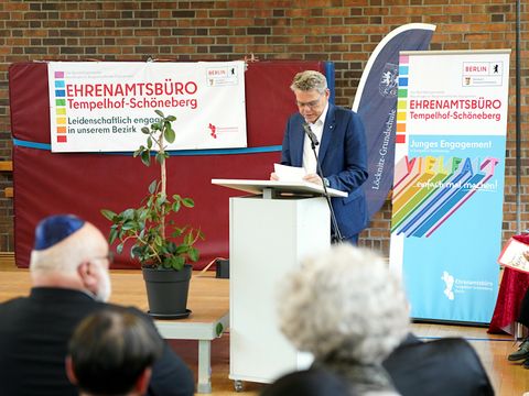 ein Mann steht an einem Rednerpult