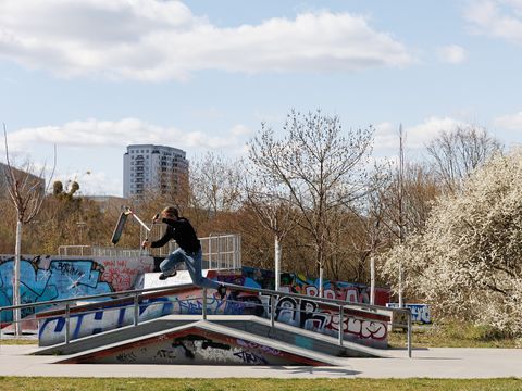 Skateanlage im Fürhling mit springendem Scooter-Fahrer