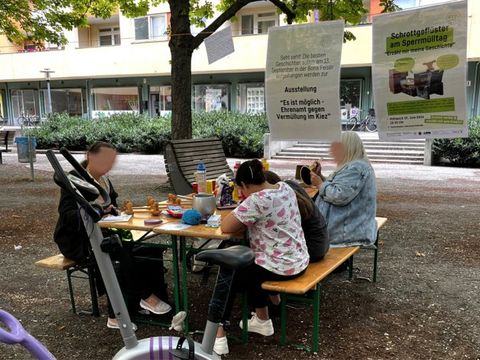 Mehrere Personen sitzen an einem Verschenke Tisch