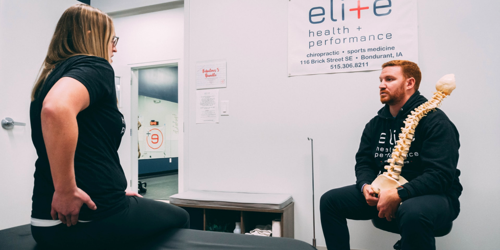 Eine Frau befindet sich in physiotherapeutischer Behandlung und schildert dem Physiotherapeuten ihre Schmerzen im unteren Rücken.