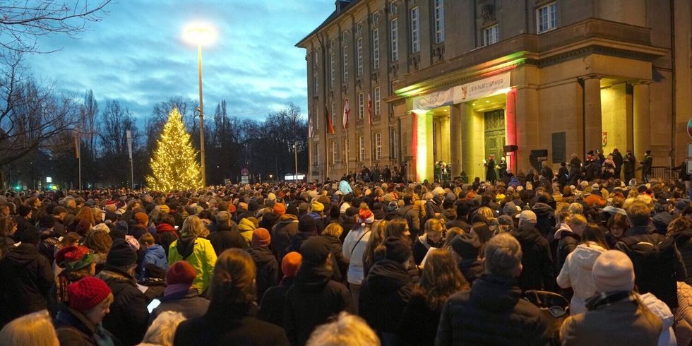 eine Menschenmenge auf dem Platz vor einem großen Gebäude