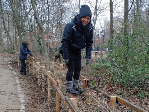 Mitarbeiter*innen beim Bau einer Totholzhecke im Naturerfahrungsraum Robinienwäldchen