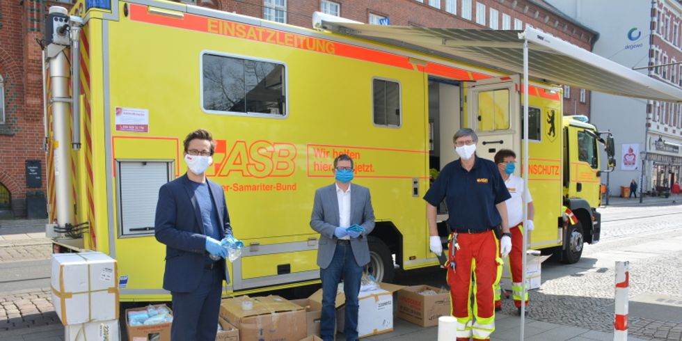 ASB-Landesgeschäftsführer Jörg Hinderberger verteilt gemeinsam mit Bezirksbürgermeister Oliver Igel MNS-Masken vor dem Rathaus Köpenick
