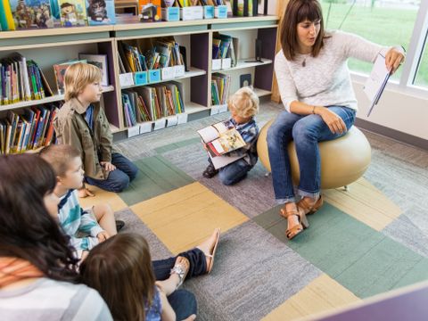 Lehrerin liest den Kindern ein Buch vor