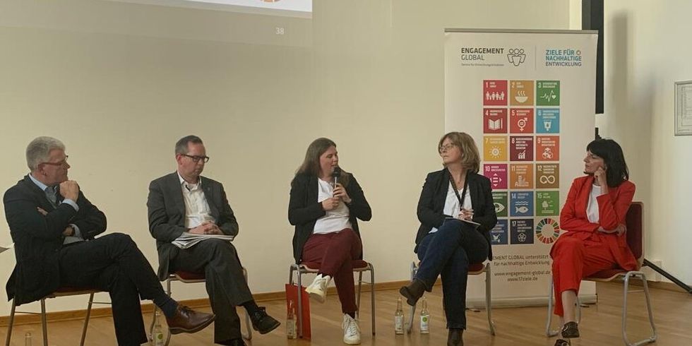 Mehrere Personen in einer Diskussionsrunde, Frau Herrmann in der Mitte
