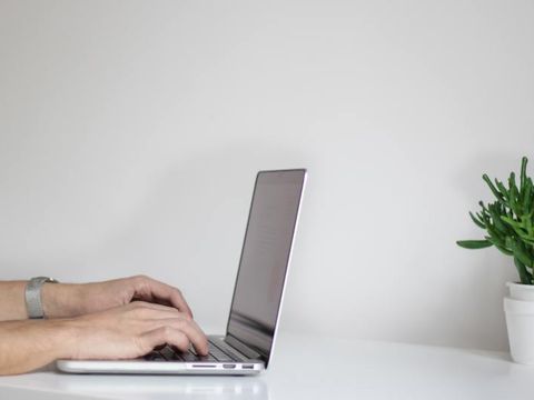 Hände tippen auf Laptop