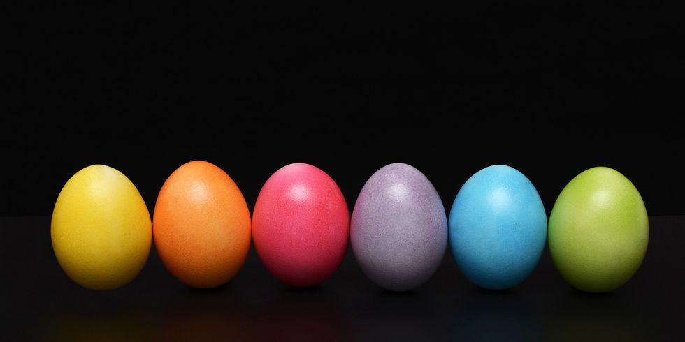 Sechs bunte Ostereier vor schwarzem Hintergrund