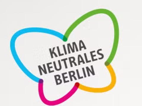 schwarzer Schriftzug klimaneutrales Berlin bunt umrahmt dicker Strich in Form eines Schmetterlings