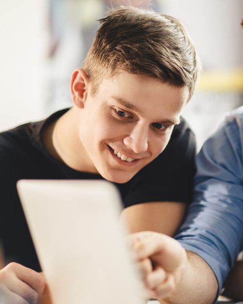 Drei Studierende schauen gemeinsam auf ein Tablet