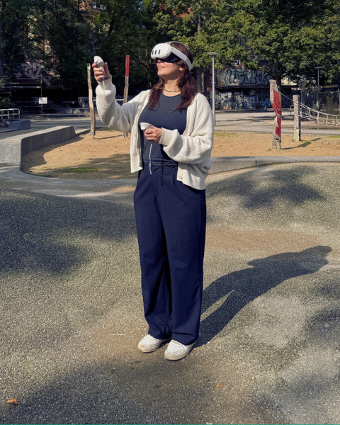 eine Frau mit einer VR-Brille steht in einem Park