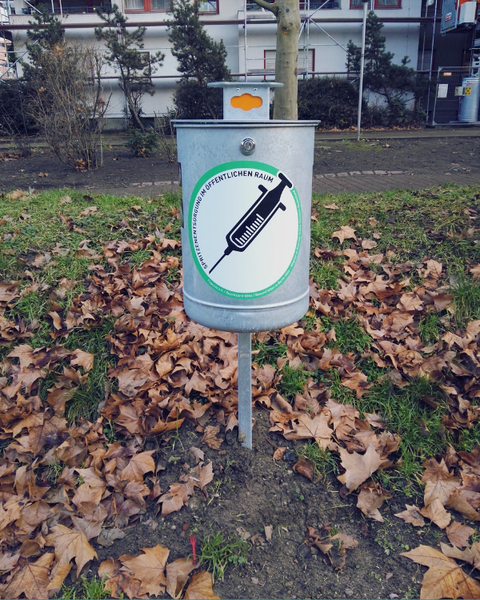 Ein Spritzenmülleimer steht in einem Park