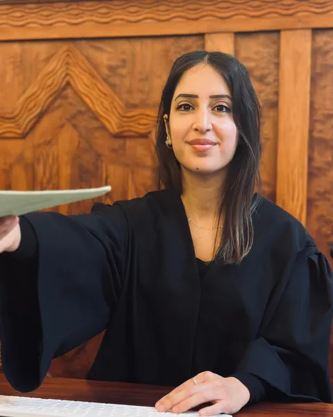 Eine Justizfachwirtin sitzt in Robe im Gerichtssaal
