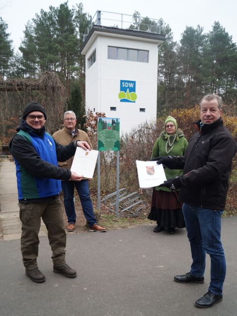 Bezirksbürgermeister Frank Balzer (vorne rechts) übergibt die Urkunde für den Reinickendorfer Umweltpreis an Vorstandsmitglied Richard Bergmann. Im Hintergrund Naturpädagogin Friedrike Blenau und der Leiter des Forstamtes, Karl-Heinz Marx (Bild: Bezirksamt Reinickendorf)